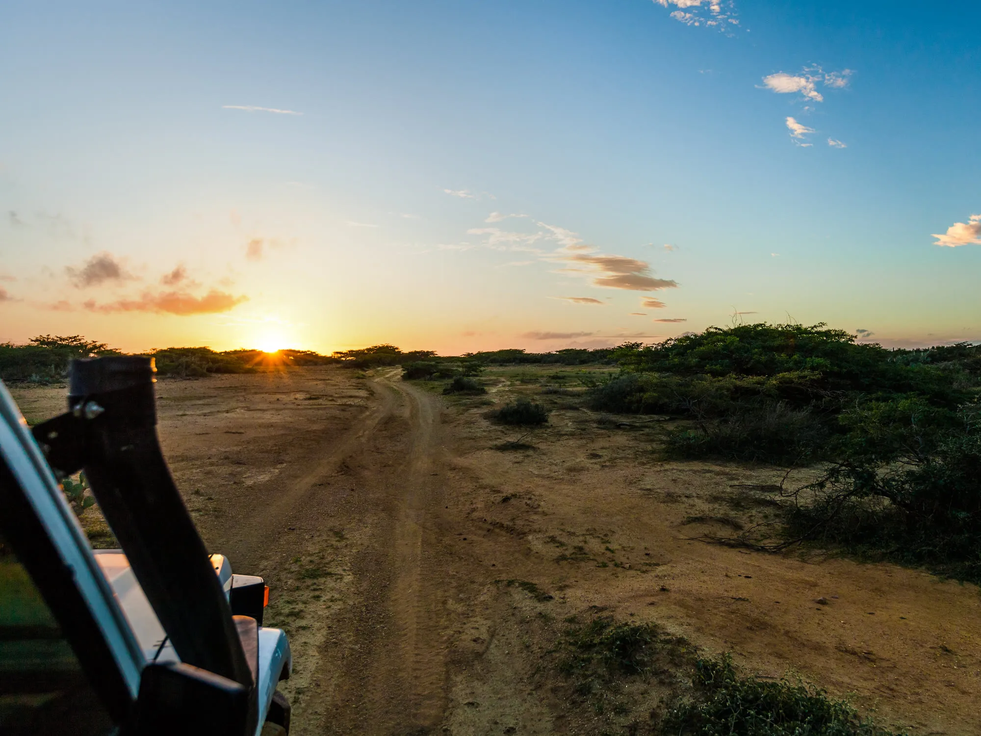 A 4×4 on a dirt track at sunset in the dry scrub of rural Colombia